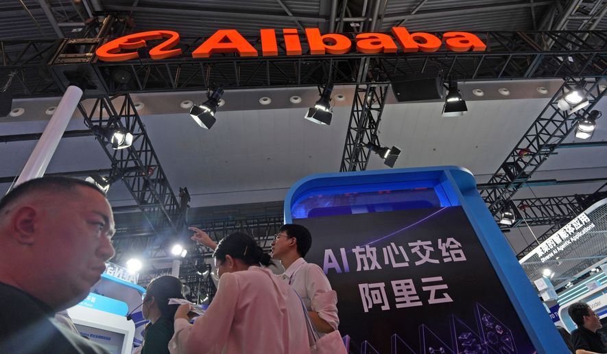 Attendees pass by the Alibaba booth near a display which reads "Rest assured giving AI to Ali Cloud" at the World AI Conference held in Shanghai on July 17, 2026. (AP Photo/Ng Han Guan)