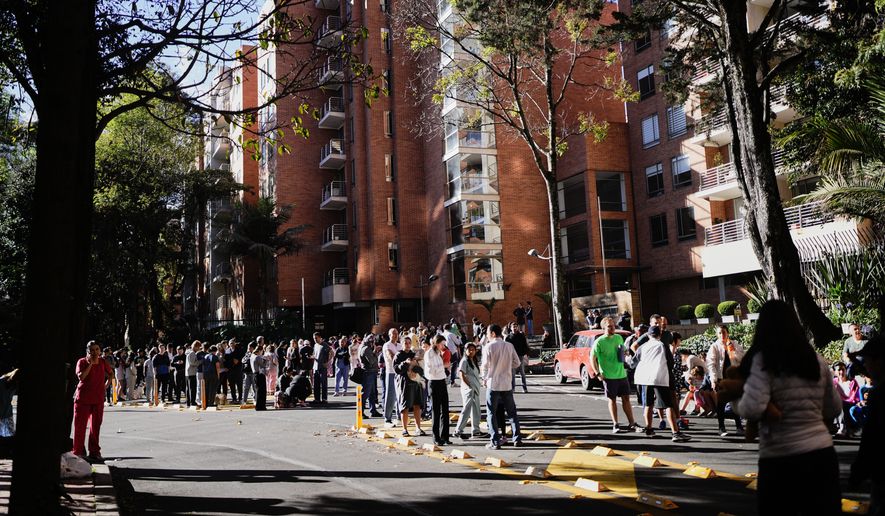 People stand outside their homes after a quake was felt in Bogota, Colombia, Monday, Aug. 10, 2026. (AP Photo/Ivan Valencia)