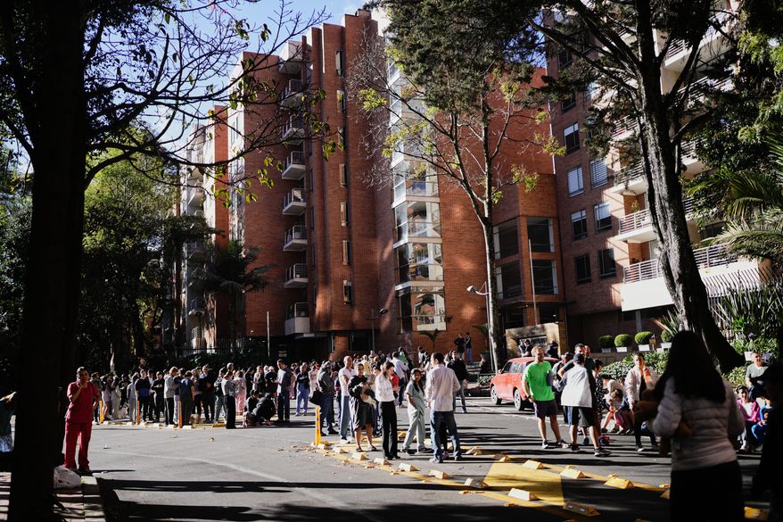 People stand outside their homes after a quake was felt in Bogota, Colombia, Monday, Aug. 10, 2026. (AP Photo/Ivan Valencia)