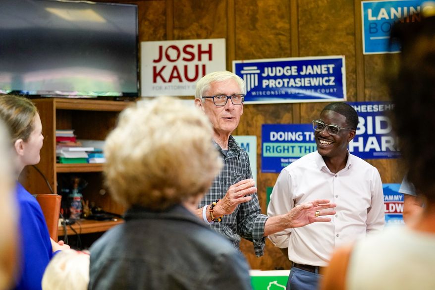 Wisconsin Gov. Tony Evers, center left, speaks in support of David Crowley, right, Democratic candidate for Wisconsin governor while campaigning at the Sheboygan County Democratic Party Friday, Aug. 7, 2026, in Sheboygan, Wis. (AP Photo/Kayla Wolf)