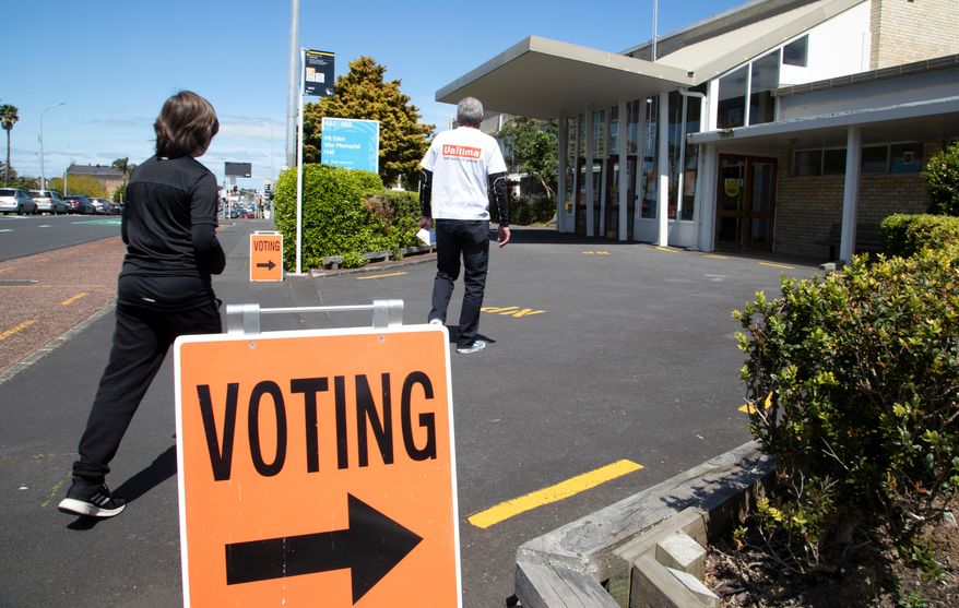 FILE - A couple arrive to vote at a polling station in Auckland, New Zealand, Oct. 17, 2020. (AP Photo/Mark Baker, File)