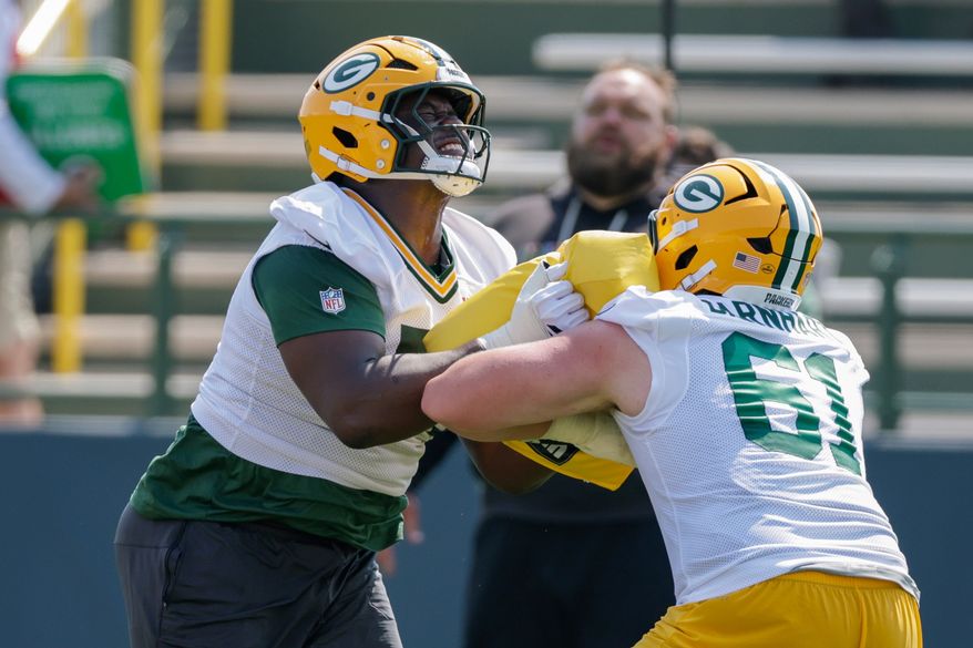 Green Bay Packers offensive tackle Anthony Belton (71) and guard Karsen Barnhart (61) run a drill during practice at the team's NFL football training camp, Thursday, July 30, 2026, in Green Bay, Wis. (AP Photo/Matt Ludtke)