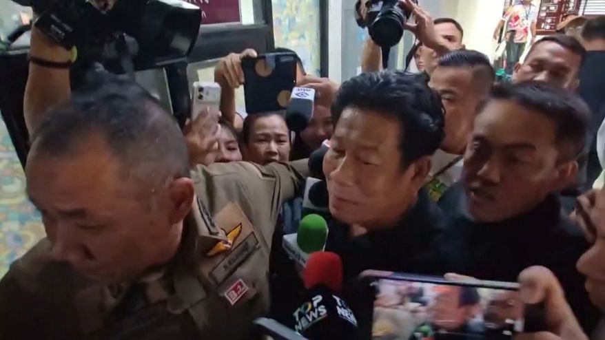 In this image made from video provided by the Thai Public Broadcasting Service, Chalong Riewraeng, center, former local Thai lawmaker, walks past media members in Nonthaburi, Thailand, Monday, Aug. 10, 2026. (TPBS via AP)