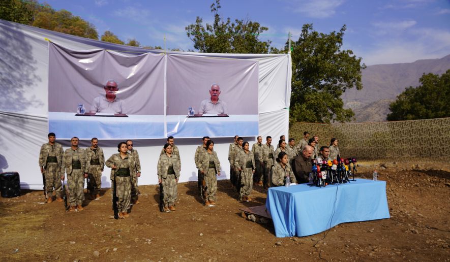 Kurdistan Workers' Party (PKK) fighters, who reportedly withdrew from Turkey with their weapons, stand to attention during a ceremony in the Qandil area of northern Iraq, щт Oct 26, 2025. (AP Photo/Rashid Yahya, File)