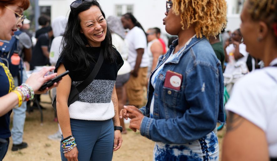 Democratic gubernatorial candidate Francesca Hong talks with Milwaukee residents during "We Outside" Annual Community Event at Metcalfe Park Rising, Friday, July 24, 2026, in Milwaukee. (AP Photo/Nam Y. Huh)