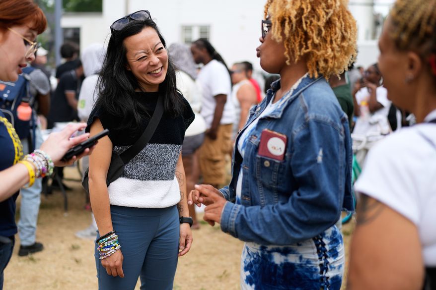 Democratic gubernatorial candidate Francesca Hong talks with Milwaukee residents during "We Outside" Annual Community Event at Metcalfe Park Rising, Friday, July 24, 2026, in Milwaukee. (AP Photo/Nam Y. Huh)