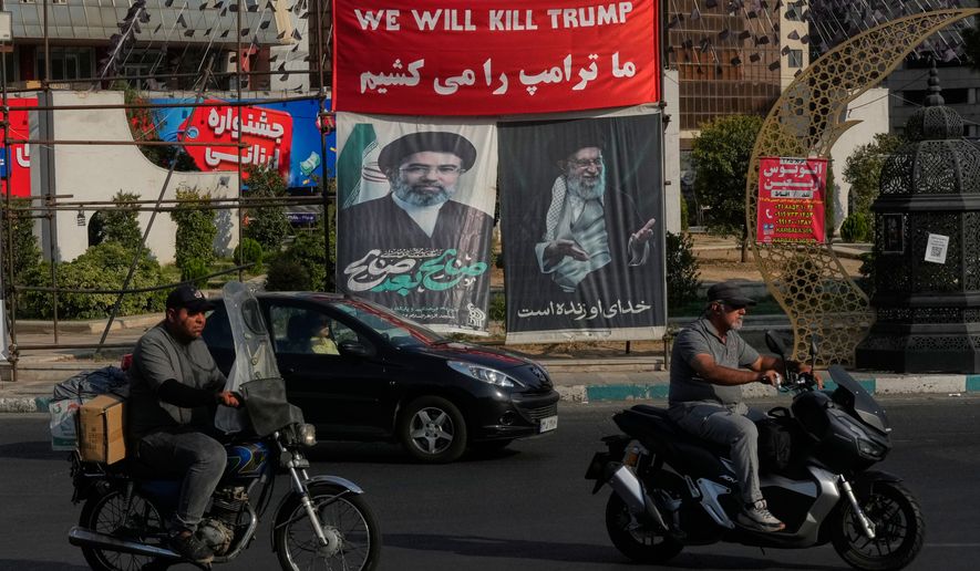 Vehicles drive past a banner reading in English and Farsi, "We will kill Trump," and banners showing portraits of the late Iranian Supreme Leader Ayatollah Ali Khamenei, right, and his son Ayatollah Mojtaba Khamenei, the successor to him, at a square in Tehran, Iran, Monday, Aug. 10, 2026. (AP Photo/Vahid Salemi)