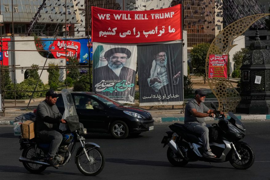 Vehicles drive past a banner reading in English and Farsi, "We will kill Trump," and banners showing portraits of the late Iranian Supreme Leader Ayatollah Ali Khamenei, right, and his son Ayatollah Mojtaba Khamenei, the successor to him, at a square in Tehran, Iran, Monday, Aug. 10, 2026. (AP Photo/Vahid Salemi)