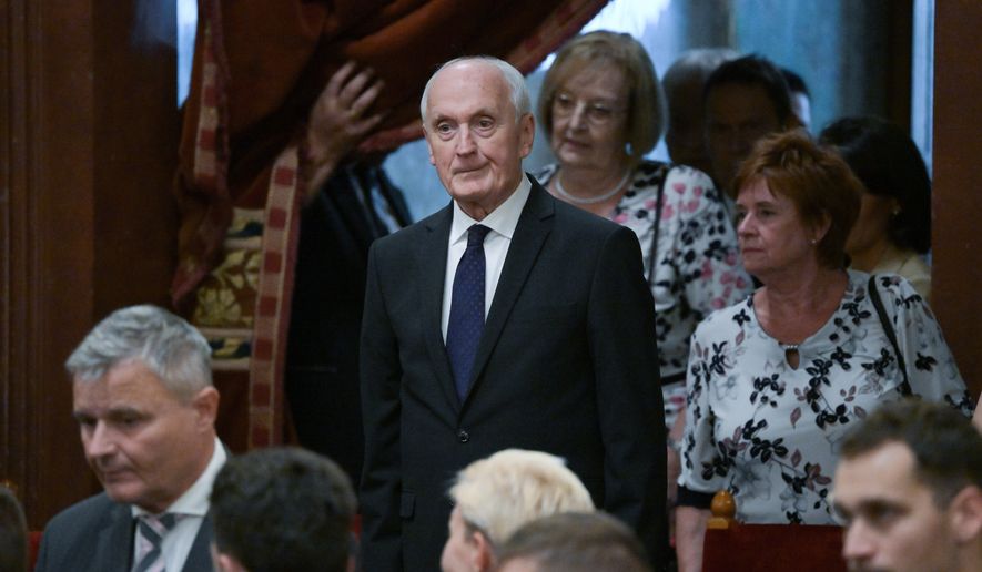 Andras Baka, sole candidate of the Tisza Party for President of the Republic of Hungary and former President of the Supreme Court, center, arrives for the presidential election during the extraordinary plenary session of the Parliament in Budapest, Hungary, Tuesday, Aug.11, 2026. (Zoltan Balogh/MTI via AP)