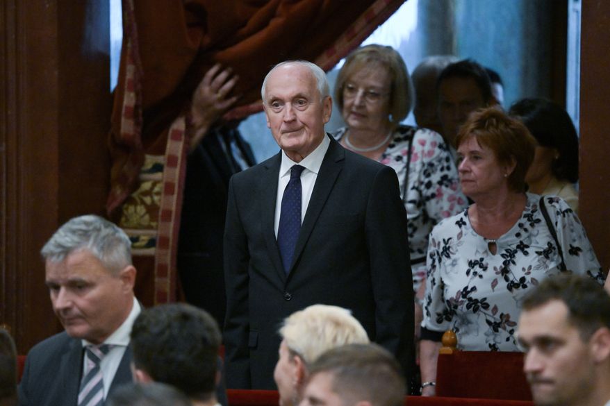 Andras Baka, sole candidate of the Tisza Party for President of the Republic of Hungary and former President of the Supreme Court, center, arrives for the presidential election during the extraordinary plenary session of the Parliament in Budapest, Hungary, Tuesday, Aug.11, 2026. (Zoltan Balogh/MTI via AP)