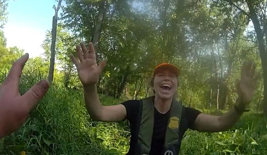 This image made from video provided by the Michigan Department of Natural Resources shows conservation officer Anna Cullen celebrating on Friday, Aug. 7, 2026, in Twin Lake, Mich., as a search and rescue team found two women and a child who had been missing after taking a river tubing trip. (