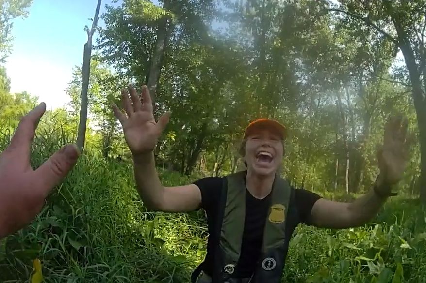 This image made from video provided by the Michigan Department of Natural Resources shows conservation officer Anna Cullen celebrating on Friday, Aug. 7, 2026, in Twin Lake, Mich., as a search and rescue team found two women and a child who had been missing after taking a river tubing trip. (