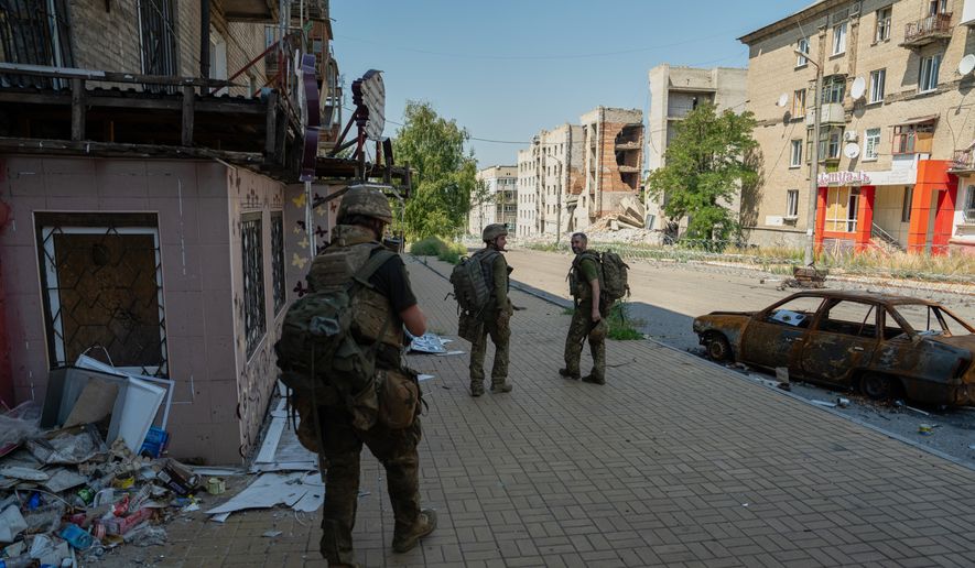 In this photo provided by Ukraine's 93rd Kholodnyi Yar Separate Mechanized Brigade press service and taken Monday, Aug. 10, 2026, Ukrainian soldiers walk along the street in the frontline town of Druzhkivka, Donetsk region, Ukraine. (Iryna Rybakova/Ukraine's 93rd Mechanized Brigade via AP))