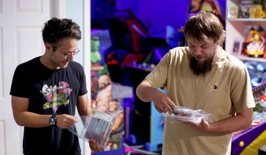 In this photo provided by Nintendo Wire, publisher Jason Ganos, left, and OneStopWonders store owner Kevin Braun hold PSA graded copies of Super Mario Bros. and Duck Hunt video games on Wednesday, June 17, 2026, which they rediscovered in a warehouse in Waukesha, Wis. (Lauren Ganos/Nintendo Wire via AP)