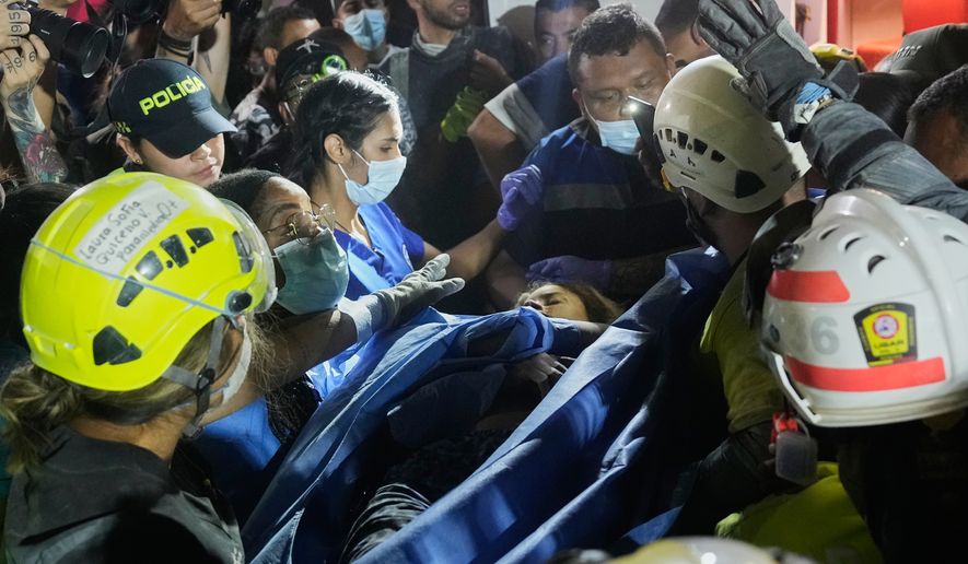 Rescue workers carry a survivor Daniela Largo after pulling her from the rubble the day after an earthquake struck Pereira, Colombia, Tuesday, Aug. 11, 2026. (AP Photo/Fernando Vergara)