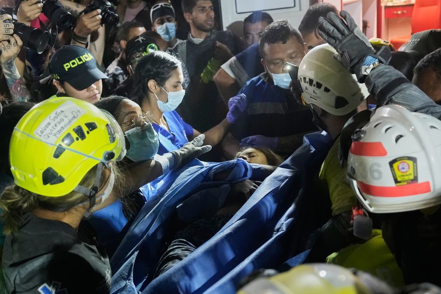 Rescue workers carry a survivor Daniela Largo after pulling her from the rubble the day after an earthquake struck Pereira, Colombia, Tuesday, Aug. 11, 2026. (AP Photo/Fernando Vergara)