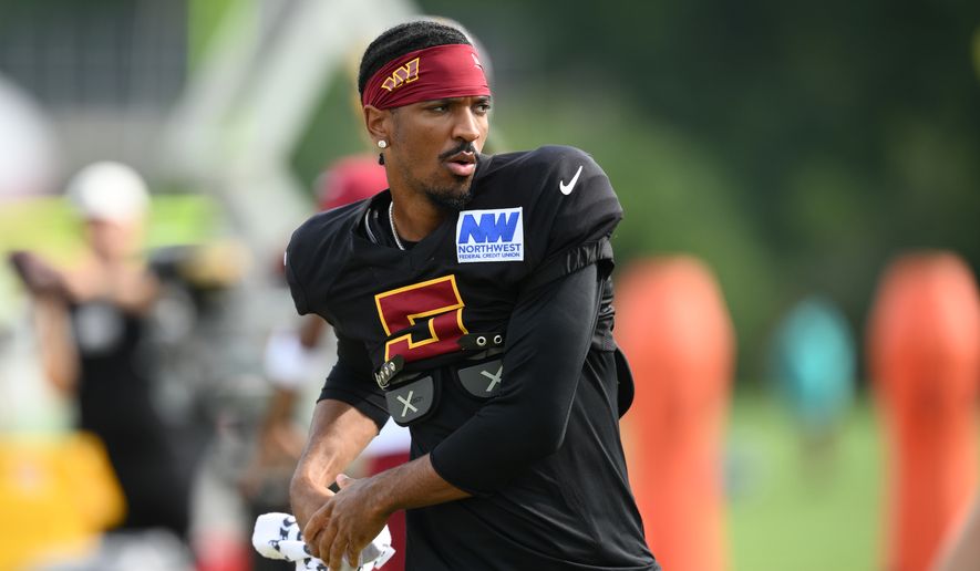 Washington Commanders quarterback Jayden Daniels works out before a joint practice with the Miami Dolphins at NFL football training camp, Wednesday, Aug. 12, 2026 in Ashburn, Va. (AP Photo/Nick Wass)