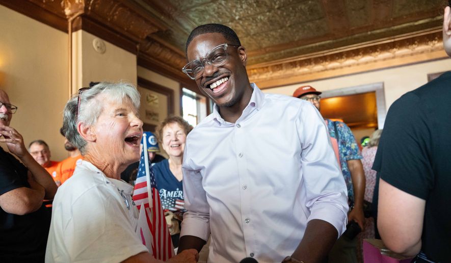 David Crowley, Democratic candidate for Wisconsin governor, shakes hands with Karen Hilt, left, during a campaign stop Friday, Aug. 7, 2026, in Sheboygan, Wis. (AP Photo/Kayla Wolf)