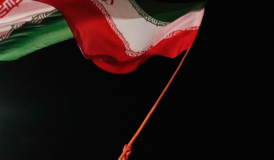 A man waves an Iranian flag during a pro-government gathering at a square in Tehran, Iran, Tuesday, Aug. 11, 2026. (AP Photo/Vahid Salemi)