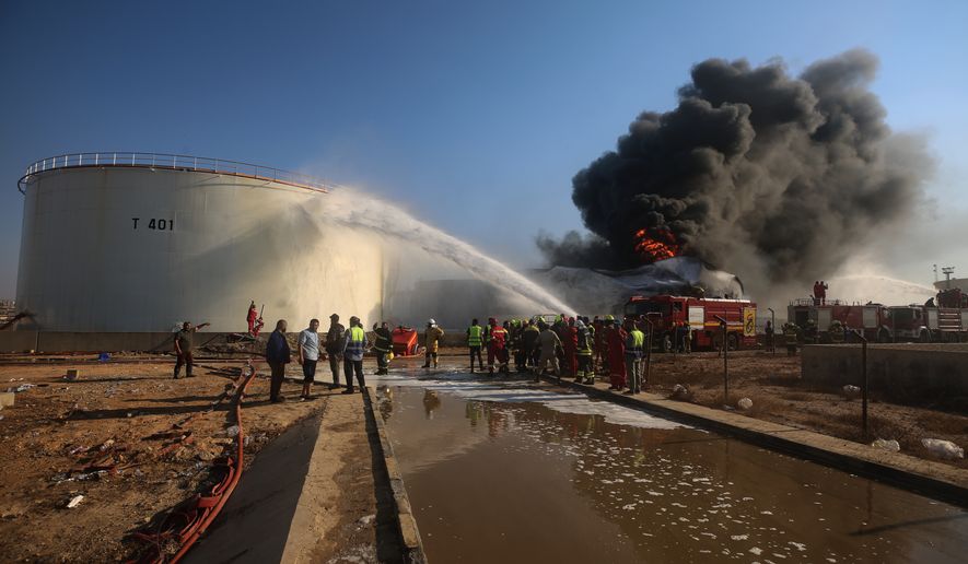 Firefighters work to contain a fire at the Zawiya oil refinery following a drone strike in Zawiya, Libya, Tuesday, Aug. 11, 2026. (AP Photo/Yousef Murad)