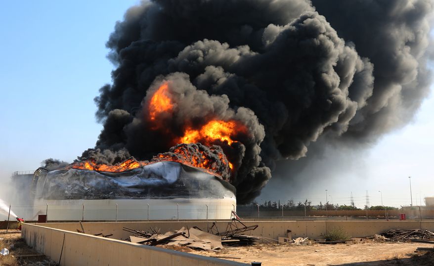 Flames and thick black smoke rise from a fuel storage tank at the Zawiya oil refinery following a drone strike in Zawiya, Libya, Tuesday, Aug. 11, 2026. (AP Photo/Yousef Murad) ** FILE **