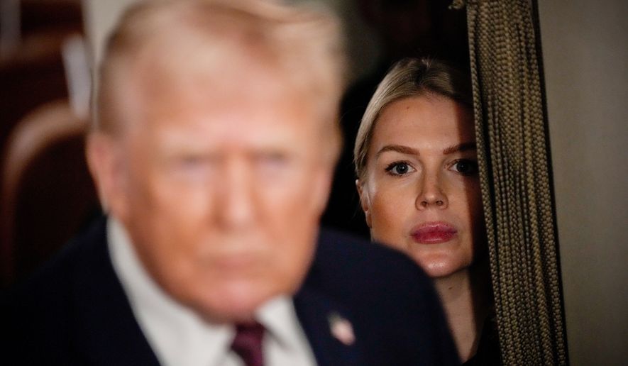 White House press secretary Karoline Leavitt watches as President Donald Trump speak to reporters while in flight on Air Force One to Joint Base Andrews, Md., Jan. 11, 2026. (AP Photo/Julia Demaree Nikhinson, File)