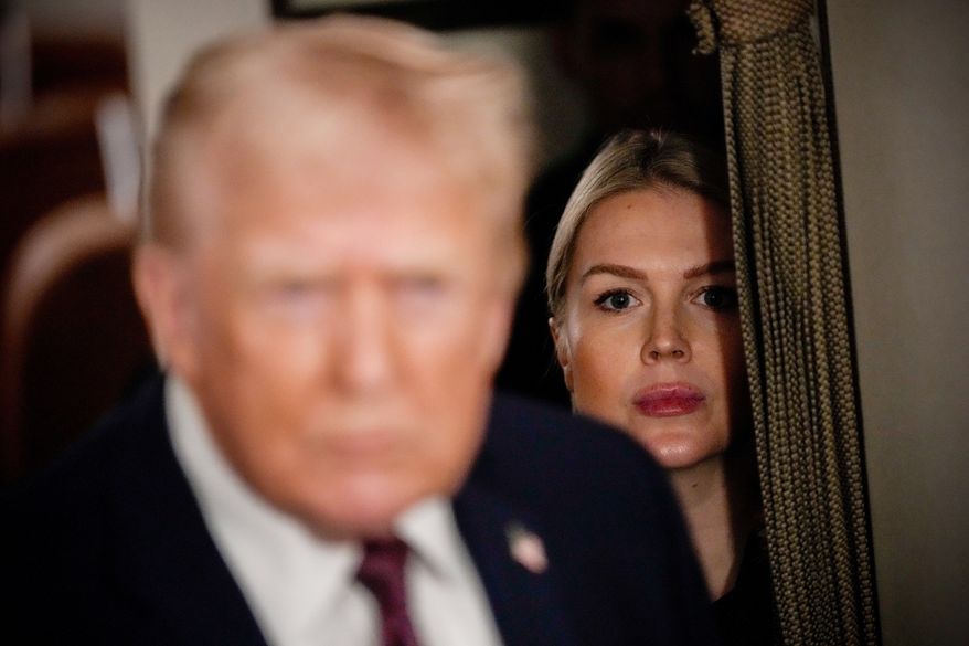 White House press secretary Karoline Leavitt watches as President Donald Trump speak to reporters while in flight on Air Force One to Joint Base Andrews, Md., Jan. 11, 2026. (AP Photo/Julia Demaree Nikhinson, File)