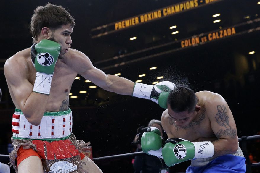 Prichard Colon, left, punches Daniel Calzada during a junior middleweight title boxing match, Saturday, April 11, 2015, at New York. Colon won by TKO. (AP Photo/Mary Altaffer)