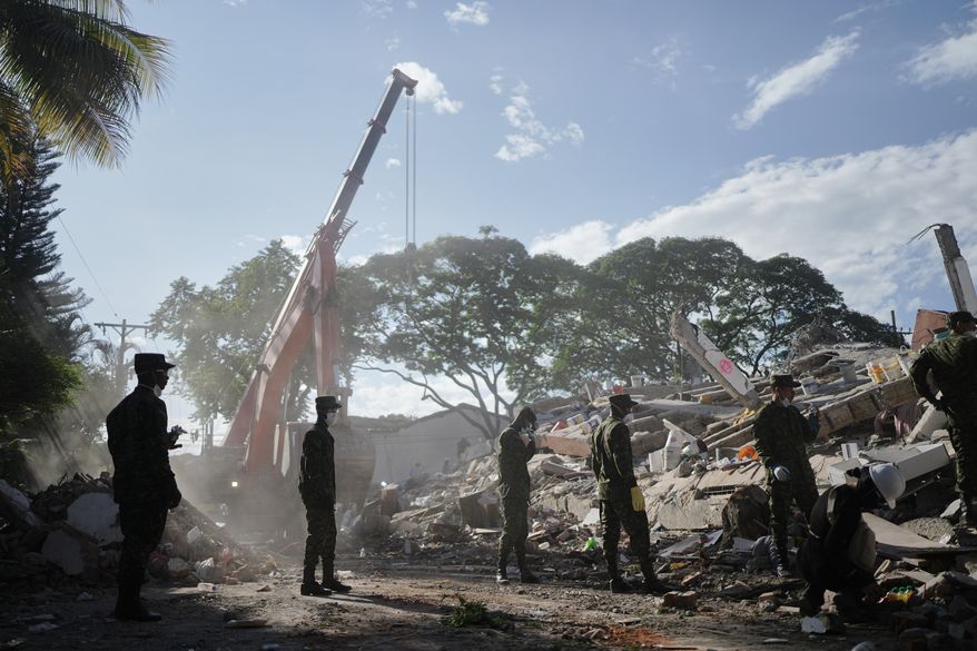 Soldiers clear debris three days after an earthquake struck Cali, Colombia, Thursday, Aug. 13, 2026. (AP Photo/Ivan Valencia)