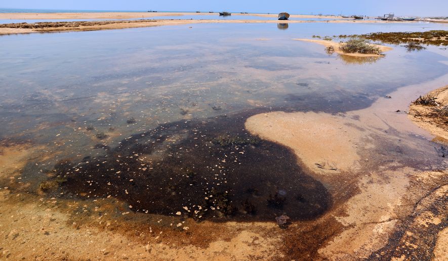 Dark oil residue collects in shallow coastal waters on Qeshm Island, Iran, Thursday, Aug. 13, 2026, amid ongoing wartime attacks on vessels and infrastructure in and around the Strait of Hormuz, though the spill's source has not been independently determined.(Amirhosein Khorgooi/ISNA via AP)