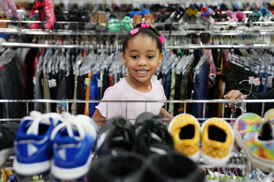 Deanna Pearson, 4, browses the children's shoe section at a Goodwill store in Roseville, Minn., Wednesday, Aug. 12, 2026. (AP Photo/Ellen Schmidt)