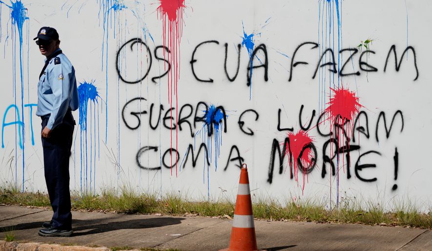 Graffiti that reads in Portuguese: "The U.S. makes war and profits from death," covers a wall at the U.S. Embassy in Brasília, Brazil, Thursday, Aug. 13, 2026. (AP Photo/Eraldo Peres)