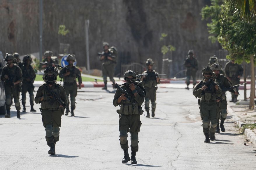 Israeli army soldiers patrol the streets of the occupied West Bank village of Qusra, south of Nablus, Thursday, Aug. 13, 2026. (AP Photo/Majdi Mohammed)