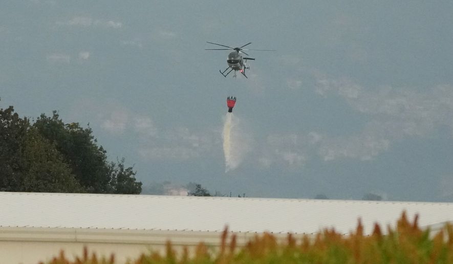 A helicopter drops water over the scene of an explosion at an ammunition plant in Colleferro, near Rome, Thursday, Aug. 13, 2026. (AP Photo/Gregorio Borgia)