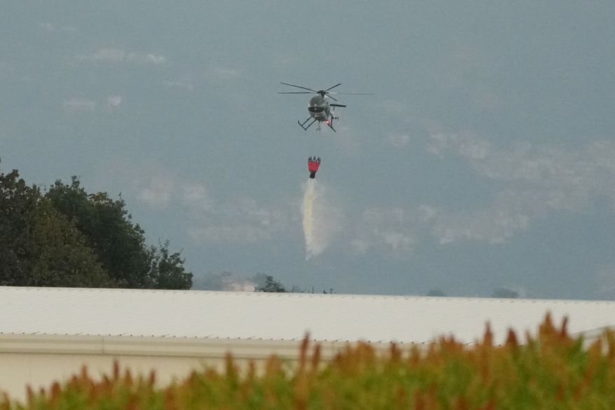 A helicopter drops water over the scene of an explosion at an ammunition plant in Colleferro, near Rome, Thursday, Aug. 13, 2026. (AP Photo/Gregorio Borgia)