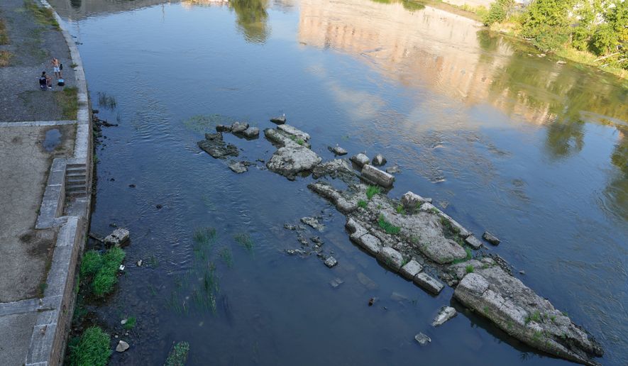 The ruins of the ancient Roman Neronian bridge, emerge from the riverbed of the Tiber river due to drought, in Rome, Thursday, Aug. 13, 2026. (AP Photo/Gregorio Borgia)