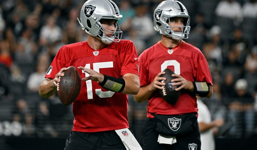 Las Vegas Raiders quarterbacks Fernando Mendoza (15) and Kirk Cousins (8) participate during an NFL football practice Tuesday, Aug. 11, 2026, in Las Vegas. (AP Photo/David Becker)