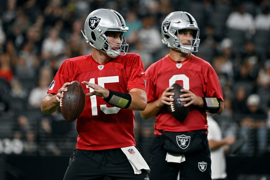 Las Vegas Raiders quarterbacks Fernando Mendoza (15) and Kirk Cousins (8) participate during an NFL football practice Tuesday, Aug. 11, 2026, in Las Vegas. (AP Photo/David Becker)