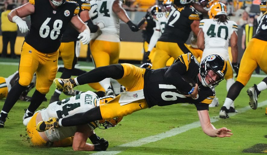 Pittsburgh Steelers quarterback Drew Allar (16) divers over Green Bay Packers linebacker Kristian Welch into the end zone for a touchdown in the second half of a preseason NFL football game in Pittsburgh, Thursday, Aug. 13, 2026. (AP Photo/Gene J. Puskar)