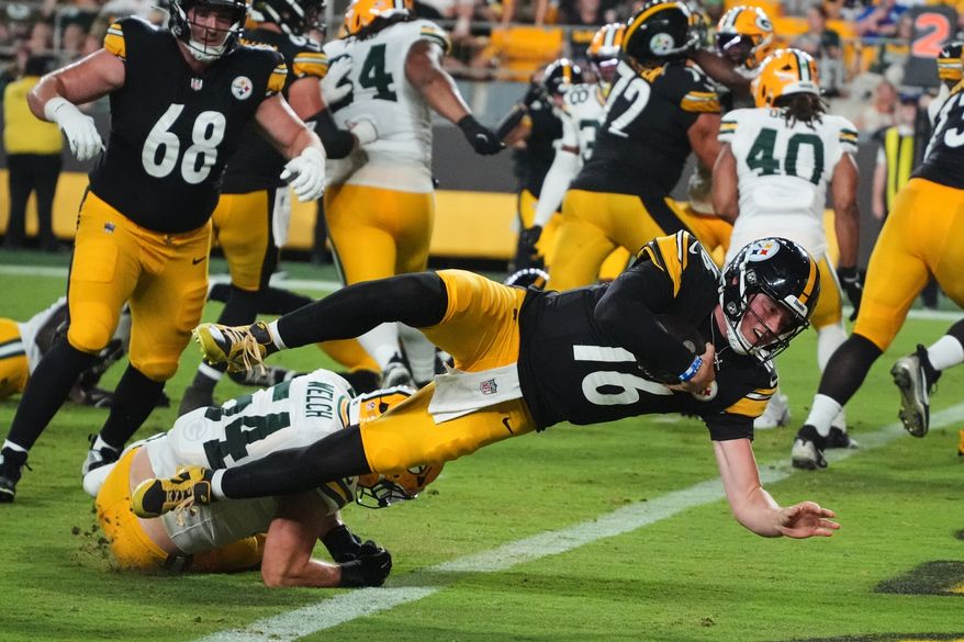 Pittsburgh Steelers quarterback Drew Allar (16) divers over Green Bay Packers linebacker Kristian Welch into the end zone for a touchdown in the second half of a preseason NFL football game in Pittsburgh, Thursday, Aug. 13, 2026. (AP Photo/Gene J. Puskar)