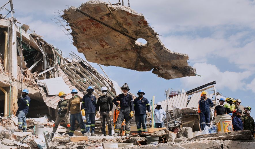 A crane lifts a concrete slab to clear the way for rescuers searching through the rubble three days after an earthquake hit Pereira, Colombia, Thursday, Aug. 13, 2026. (AP Photo/Brandon Pinto)