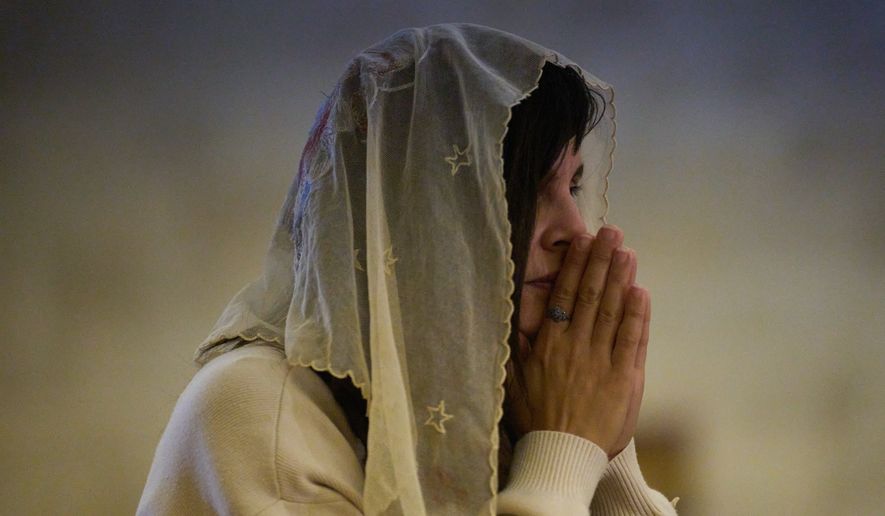 A Christian pilgrim attends a Mass in the Basilica of the Transfiguration on Mount Tabor, northern Israel, Aug. 6, 2026. (AP Photo/Ariel Schalit)