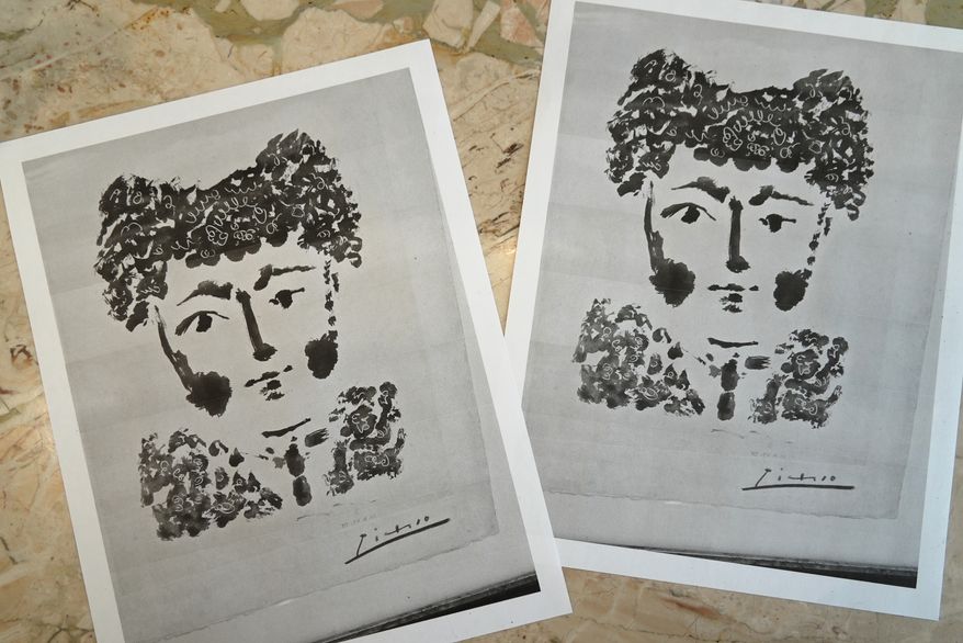 Printouts of a photo of the Pablo Picasso etching, "Torero" are displayed on a table in DeLind Fine Art Appraisals in Milwaukee on Aug. 14, 2026. (AP Photo/Laura Bargfeld)