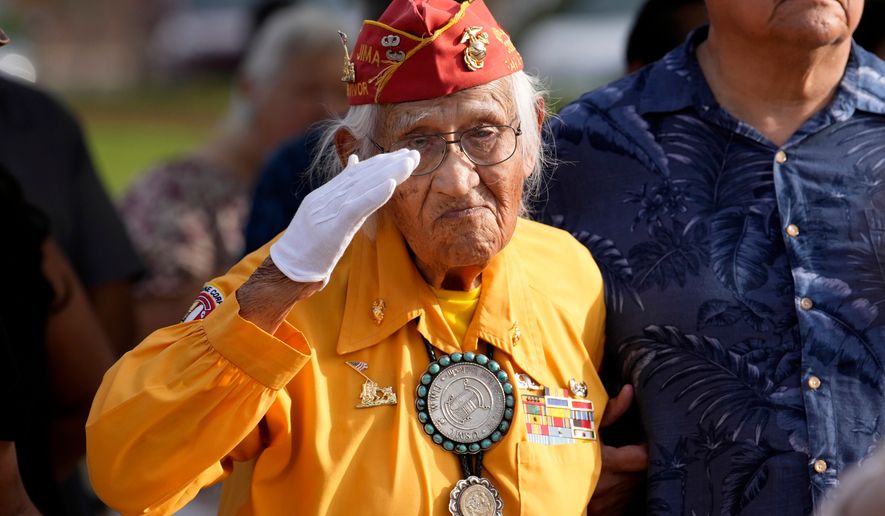 Navajo Code Talker Thomas Begay salutes during the national anthem during a ceremony on Navajo Code Talkers Day, Friday, Aug. 14, 2026, in Phoenix. (AP Photo/Ross D. Franklin)