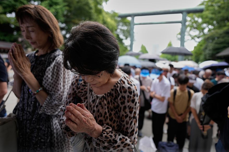 Visitors observe a moment of silence at Yasukuni Shrine, which honors Japan's war dead, including convicted war criminals, as the country marks the 81st anniversary of the end of World War II Saturday, Aug. 15, 2026, in Tokyo. (AP Photo/Eugene Hoshiko)