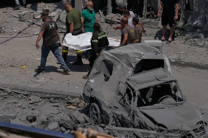 Rescue workers carry a plastic bag, containing the body of a person who was killed at a house that was hit by an Israeli airstrike in Deir al-Zahrani village, southern Lebanon, Saturday, Aug. 15, 2026. (AP Photo/Mohammed Zaatari)