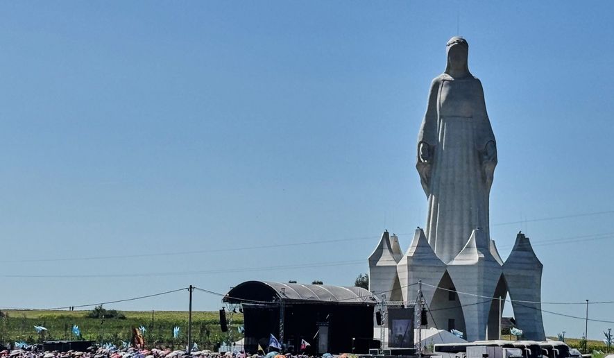People gather near an enormous statue of the Virgin Mary that is believed to be Europe's tallest during the inauguration in the village Konotopie, Poland, Saturday, Aug. 15, 2026. (AP Photo/Claudia Ciobanu)