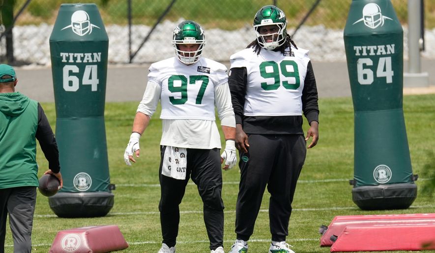New York Jets' Harrison Phillips (97) and T'Vondre Sweat (99) participate in an NFL football practice in Florham Park, N.J., June 10, 2026. (AP Photo/Seth Wenig, File)