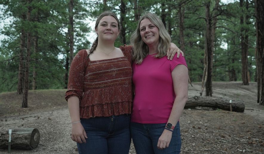 Charlotte Touzalin stands with her mother, Anne Schultz, Friday, July 10, 2026 in Elizabeth, Colo. (AP Photo/Brittany Peterson)