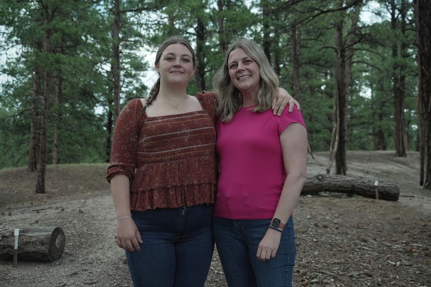 Charlotte Touzalin stands with her mother, Anne Schultz, Friday, July 10, 2026 in Elizabeth, Colo. (AP Photo/Brittany Peterson)